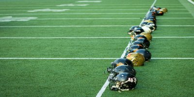 Helmets by Paolo Aldrighetti american football helmets lined up on field
