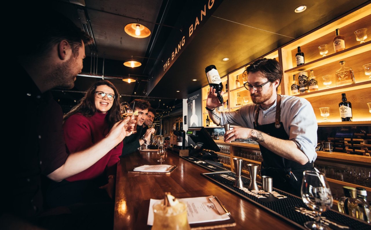 people enjoying whiskey tastings at bar 